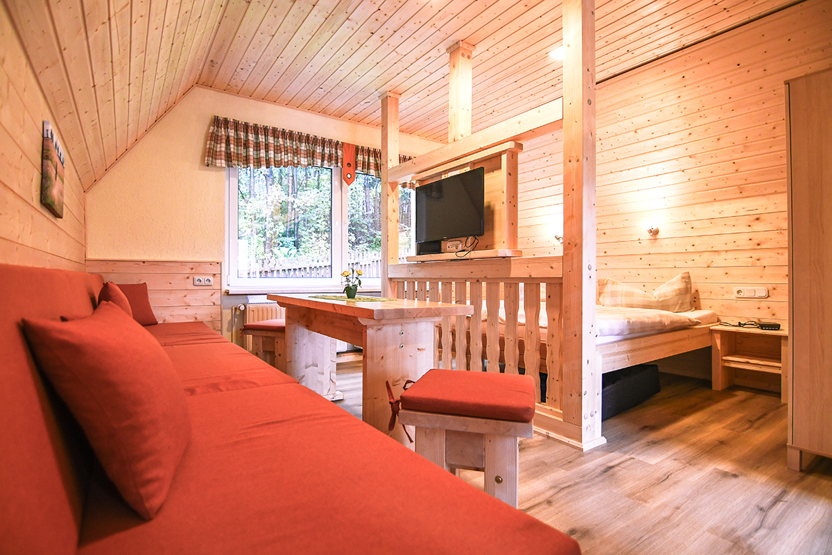Sitzbereich mit drehbarem TV in unseren Finnhütten